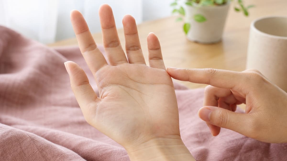やわらかい自然光の下で小指側の手の側面にある短い結婚線を観察している様子