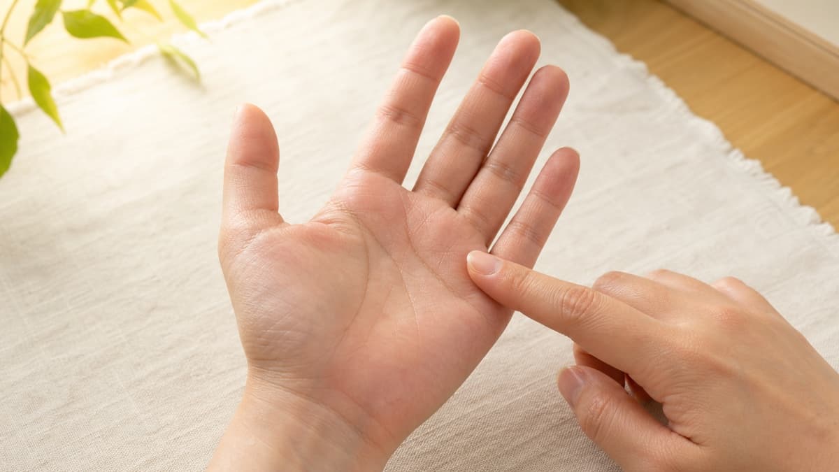 自然光の下で薬指の付け根へ向かう太陽線を観察している様子
