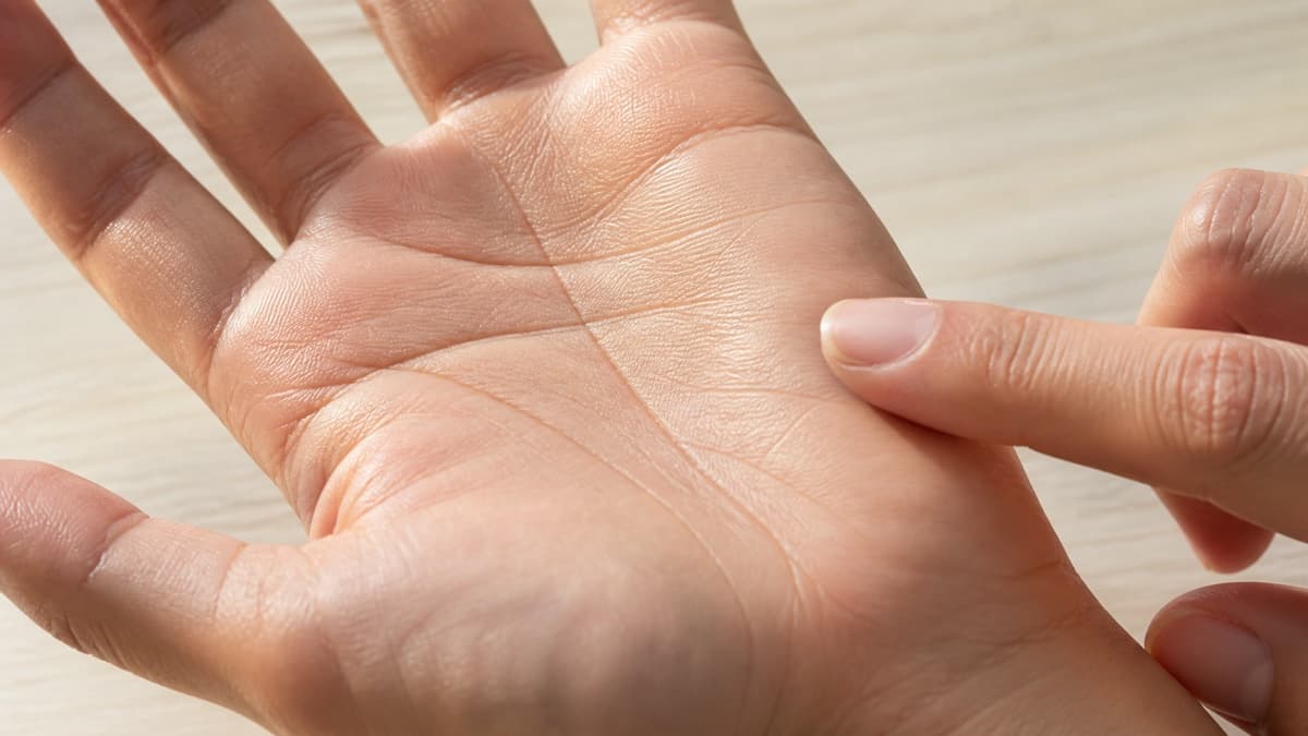 やわらかい光の下で手のひらの線の幅と溝の見え方を観察している様子