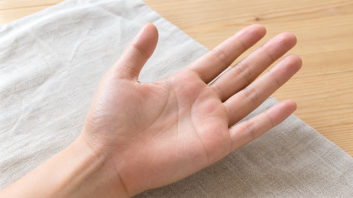 自然光の下で人差し指の付け根の下を囲む短い弧を観察している様子